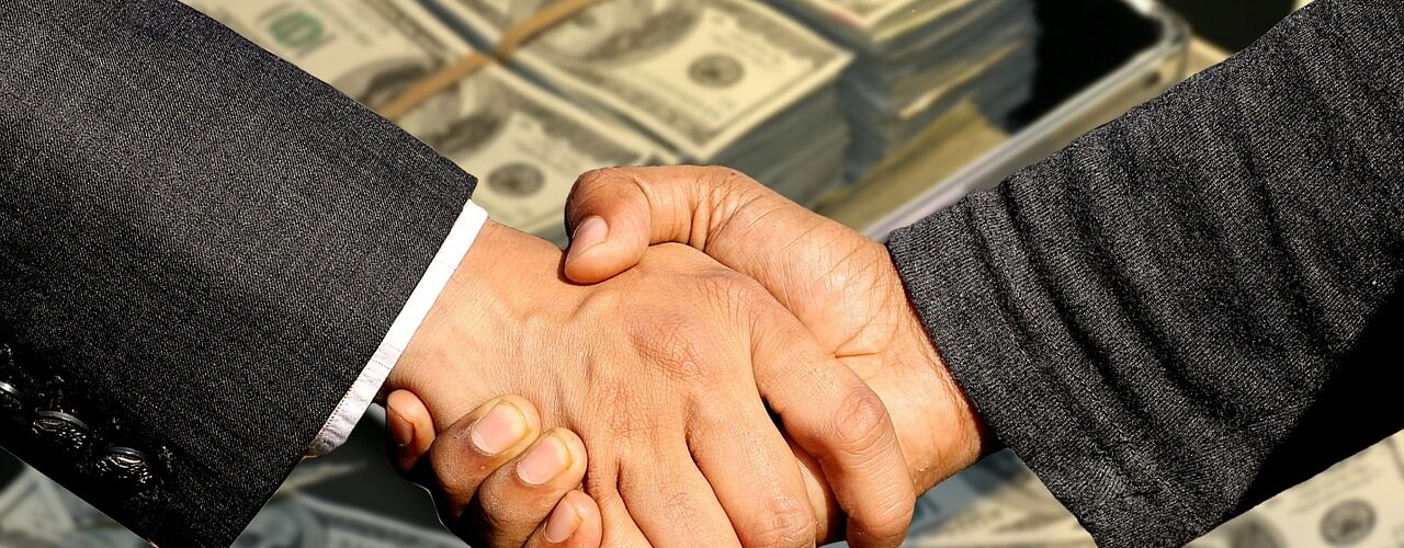 Two men shaking hands , Money at the background