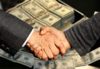 Two men shaking hands , Money at the background