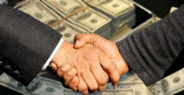 Two men shaking hands , Money at the background