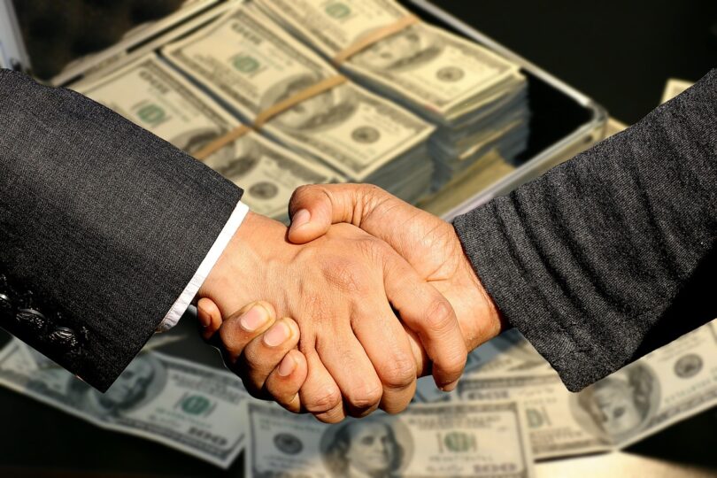 Two men shaking hands , Money at the background