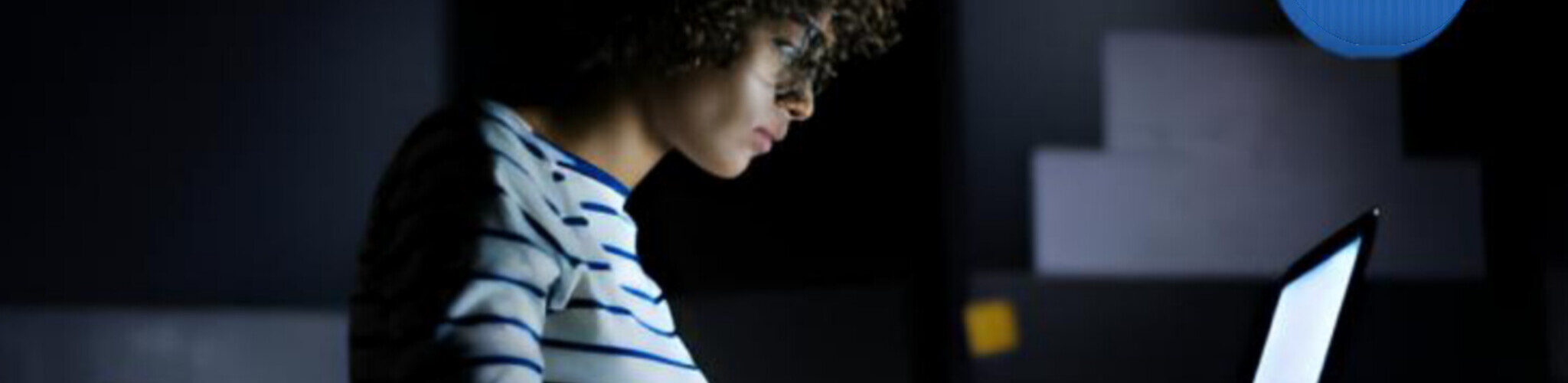 A young dark skinned girl working with her laptop at night